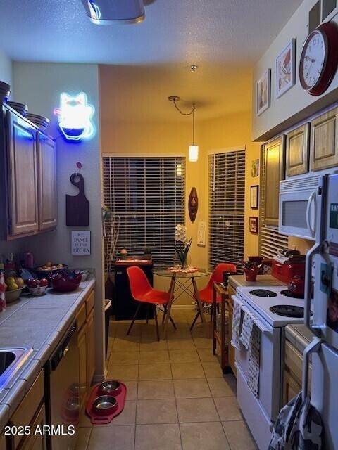 14950 W Mountain View Blvd Unit 5303, Surprise, AZ 85374 - kitchen with white appliances, light tile patterned flooring, tile countertops, and decorative light fixtures