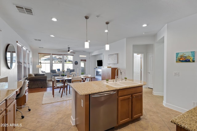 kitchen featuring sink, decorative light fixtures, ceiling fan, stainless steel dishwasher, and a kitchen island with sink