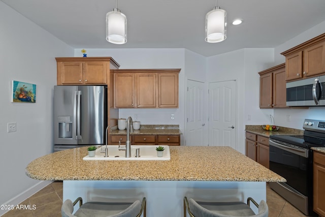 kitchen with appliances with stainless steel finishes, a kitchen breakfast bar, a kitchen island with sink, and sink