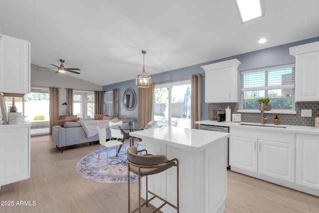 21640 N 48th St, Phoenix, AZ 85054 - kitchen with decorative backsplash, a center island, light countertops, vaulted ceiling, and a sink