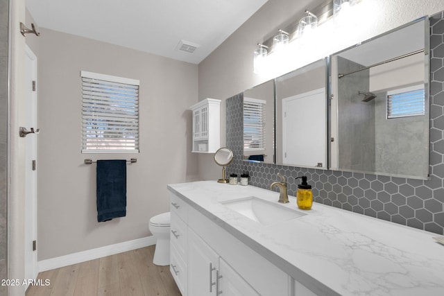 21640 N 48th St, Phoenix, AZ 85054 - full bath with baseboards, toilet, wood finished floors, vanity, and backsplash
