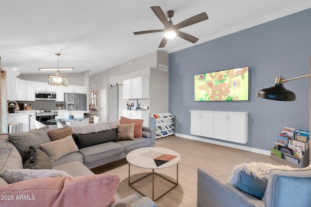 21640 N 48th St, Phoenix, AZ 85054 - living room featuring light wood finished floors, lofted ceiling, visible vents, a ceiling fan, and baseboards