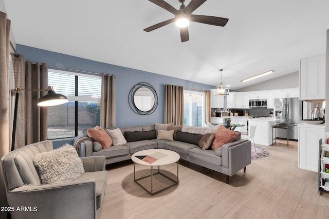 21640 N 48th St, Phoenix, AZ 85054 - living area featuring lofted ceiling, light wood-style flooring, and ceiling fan with notable chandelier