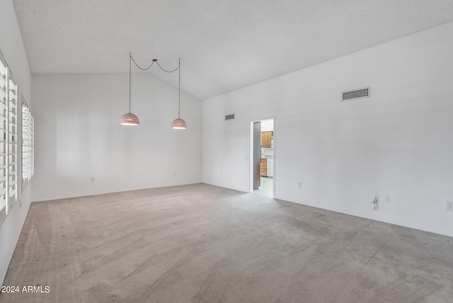 unfurnished room with light carpet, a textured ceiling, and high vaulted ceiling