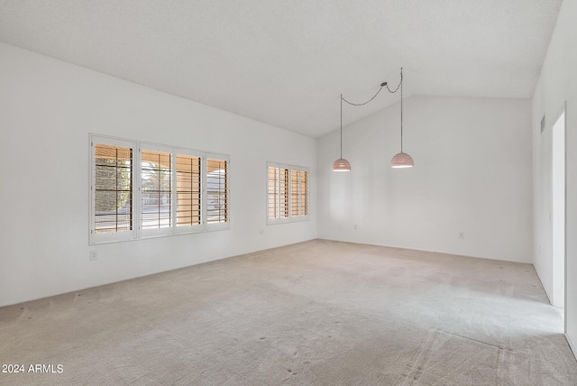 carpeted empty room featuring vaulted ceiling