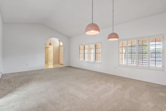 carpeted spare room featuring vaulted ceiling