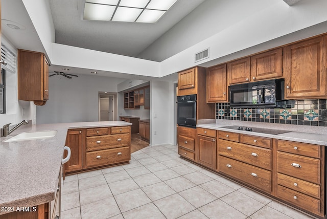 kitchen with light tile patterned flooring, ceiling fan, sink, kitchen peninsula, and black appliances