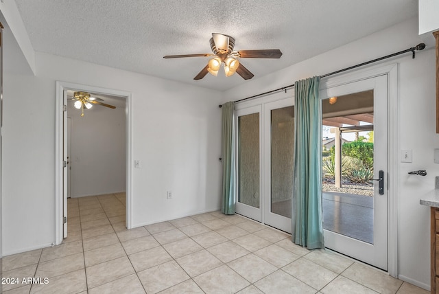 tiled spare room featuring ceiling fan and a textured ceiling