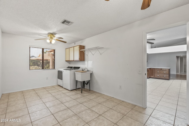 laundry area featuring washer and dryer, cabinets, and a textured ceiling