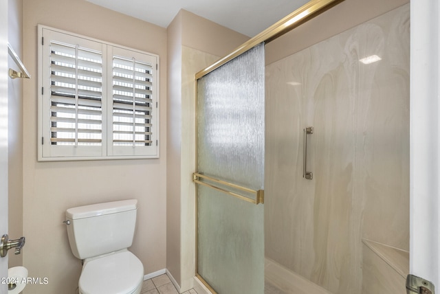 bathroom featuring tile patterned flooring, a shower with door, and toilet