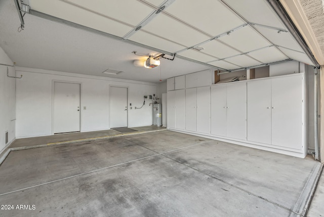 garage featuring a garage door opener and water heater