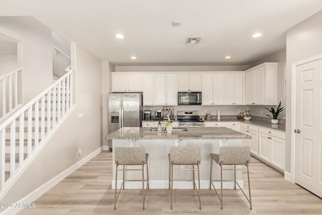 263 N Wilson Dr, Chandler, AZ 85225 - kitchen featuring stainless steel appliances, a center island with sink, white cabinetry, a kitchen breakfast bar, and recessed lighting
