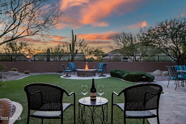 yard at dusk with an outdoor fire pit and a patio area