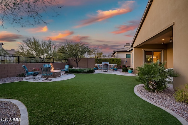 yard at dusk with a patio area and a fire pit