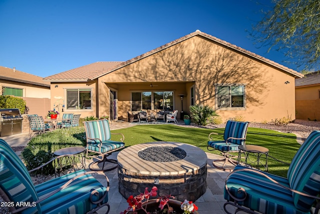 back of property featuring a fire pit, a patio area, and a lawn