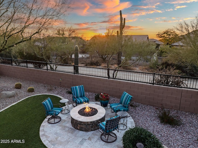 patio terrace at dusk featuring an outdoor fire pit