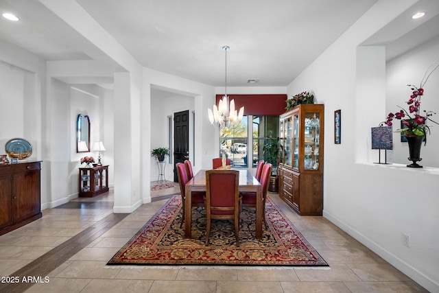 tiled dining area featuring a notable chandelier