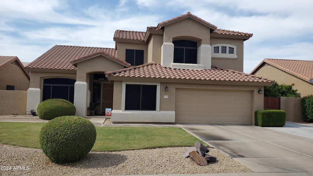 mediterranean / spanish home with a front yard and a garage