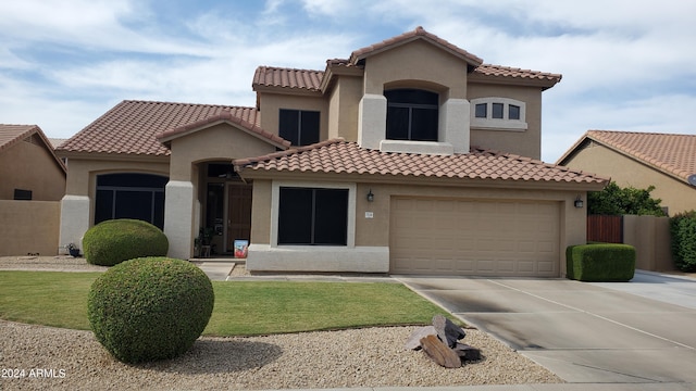 mediterranean / spanish home with a front yard and a garage