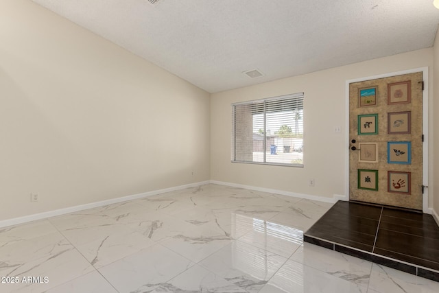 643 W Medina Ave, Mesa, AZ 85210 - empty room with marble look tiles, baseboards, and a textured ceiling