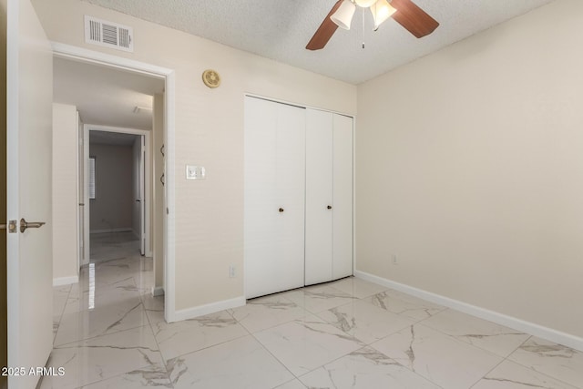 643 W Medina Ave, Mesa, AZ 85210 - unfurnished bedroom featuring light marble finish floors, baseboards, a closet, and a textured ceiling