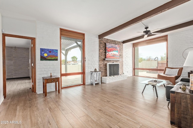 17346 E Oro Grande Dr, Fountain Hills, AZ 85268 - living area featuring ceiling fan, brick wall, beamed ceiling, light wood finished floors, and a fireplace
