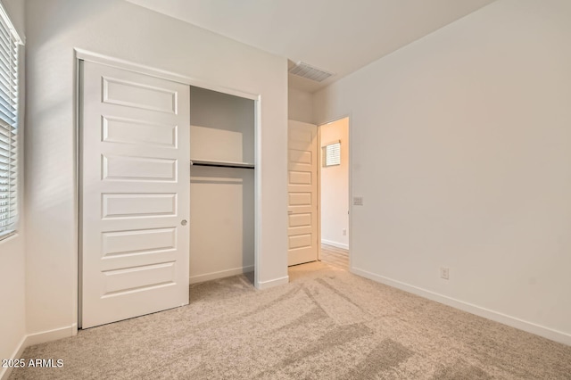 unfurnished bedroom with carpet flooring, a closet, baseboards, and visible vents