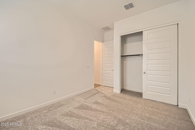 unfurnished bedroom featuring baseboards, carpet floors, visible vents, and a closet