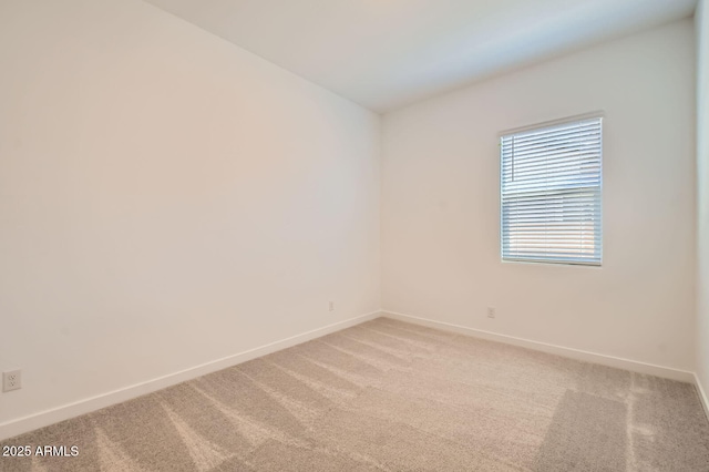 unfurnished room featuring light colored carpet and baseboards