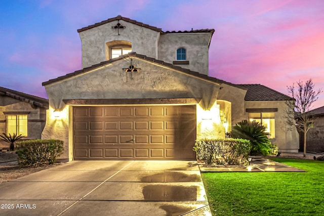 mediterranean / spanish-style home with a garage and a lawn