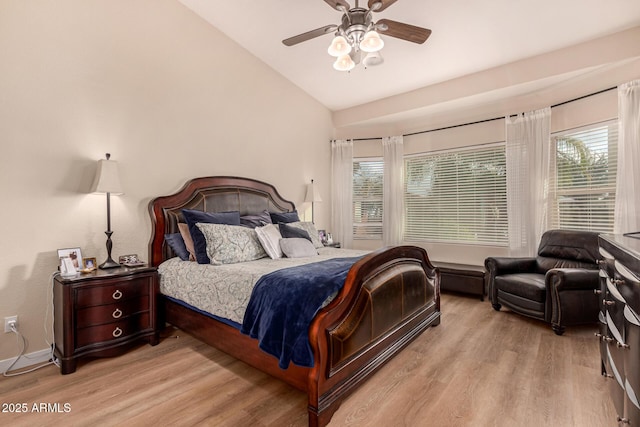 bedroom with multiple windows, lofted ceiling, ceiling fan, and light hardwood / wood-style flooring