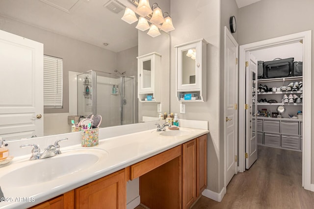 bathroom with vanity, hardwood / wood-style flooring, and a shower with door