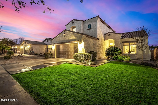 mediterranean / spanish-style house featuring a yard and a garage