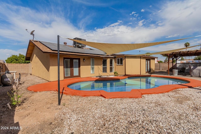 3837 W Dailey St, Phoenix, AZ 85053 - back of house with french doors, a fenced in pool, a fenced backyard, and roof mounted solar panels