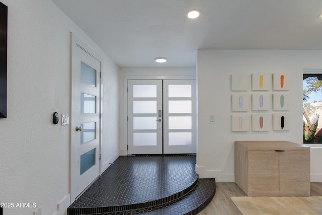 foyer entrance featuring french doors and light hardwood / wood-style flooring