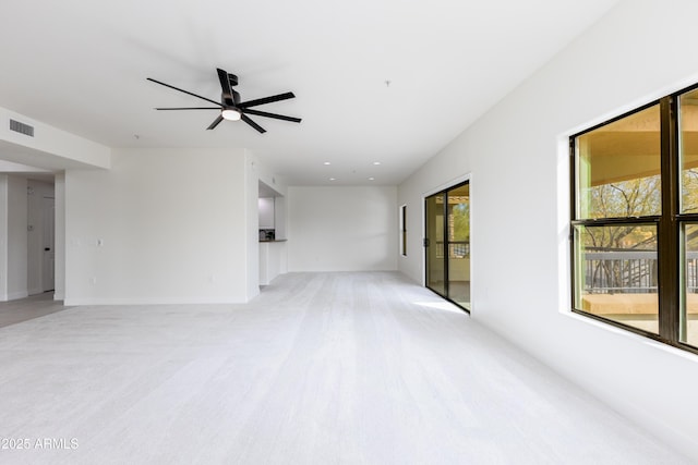 interior space with ceiling fan and light colored carpet