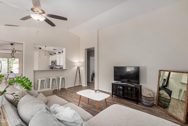 living room with vaulted ceiling, ceiling fan, and dark wood-type flooring