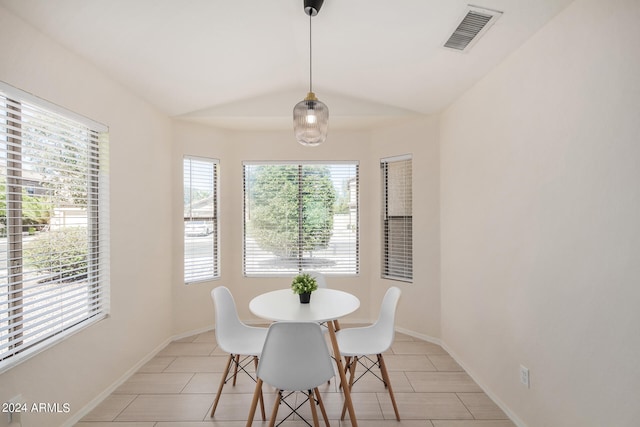 tiled dining room featuring vaulted ceiling and a wealth of natural light