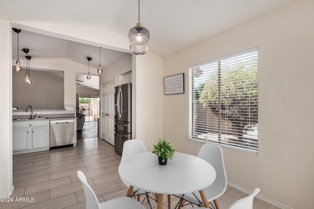 dining room with a wealth of natural light, vaulted ceiling, and sink