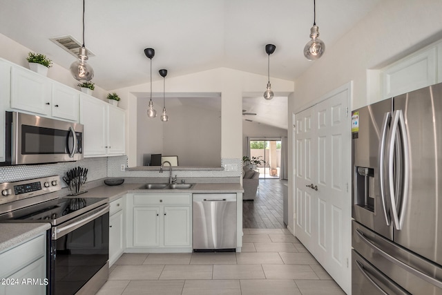 kitchen with sink, white cabinets, vaulted ceiling, hanging light fixtures, and stainless steel appliances