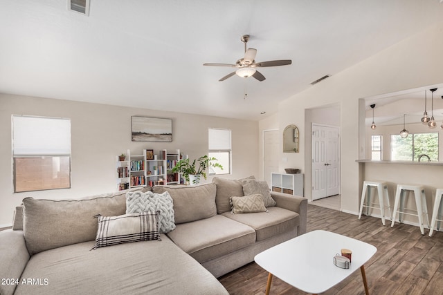 living room featuring wood-type flooring, lofted ceiling, ceiling fan, and sink