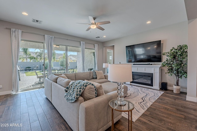 living room with dark wood-type flooring and ceiling fan