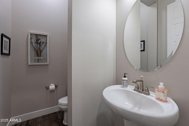 bathroom featuring wood-type flooring, toilet, and sink