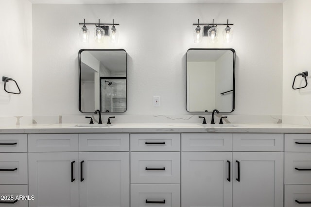 bathroom featuring a stall shower, a sink, and double vanity