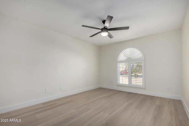 spare room featuring light wood-style floors, ceiling fan, and baseboards