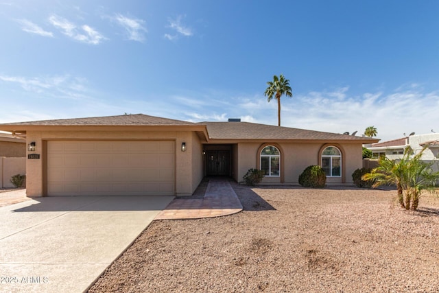 ranch-style house featuring an attached garage, concrete driveway, and stucco siding