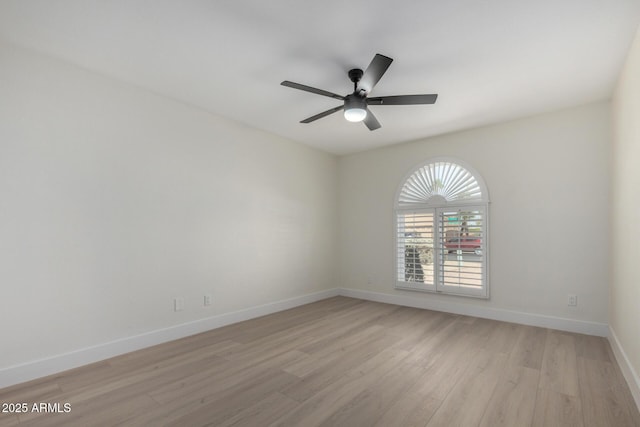 unfurnished room featuring baseboards, ceiling fan, and light wood finished floors