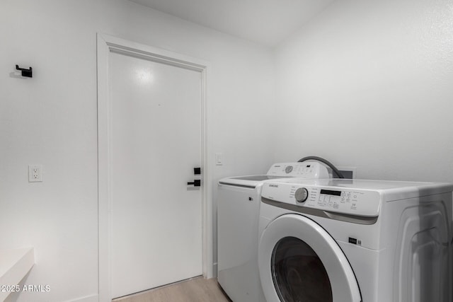 clothes washing area with laundry area, independent washer and dryer, and light wood finished floors