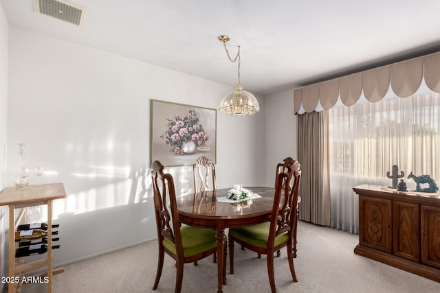 dining room featuring visible vents, a notable chandelier, and light carpet