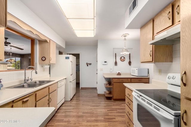 kitchen with visible vents, a sink, tasteful backsplash, and white appliances